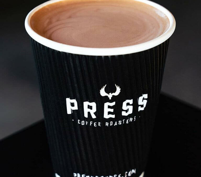Cup of coffee in to-go coffee cup. Press Coffee Roasters. Presscoffee.com