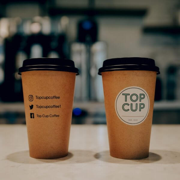 Two to-go coffee cups with Top Cup logo