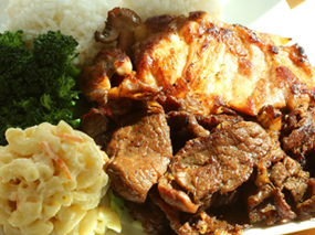 Plate with macaroni salad, bbq ribs and chicken, with a side of rice and broccoli.