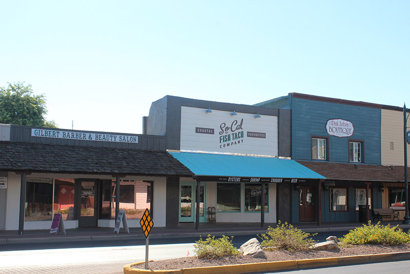 Three storefronts. Gilbert Barber & Beauty Salon, SoCal Fish Taco Company, and Pink Zebra Boutique.