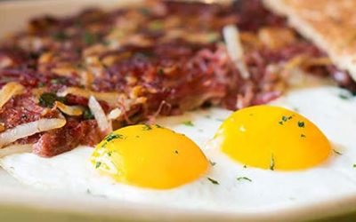 Two fried eggs with corn beef hash.