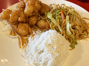 Plate of white rice, orange chicken, and chow mein.