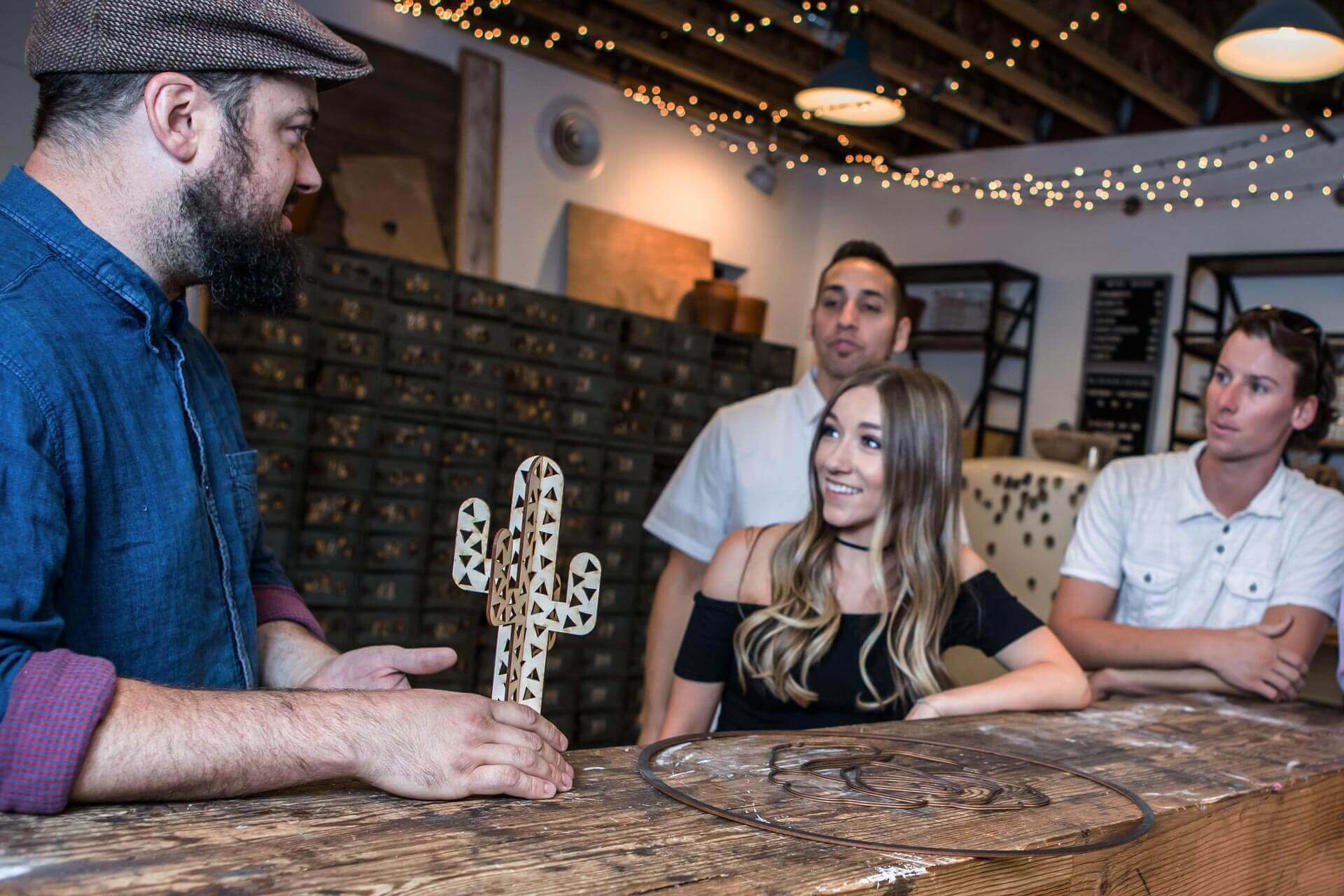 Patrons looking at wooden cactus
